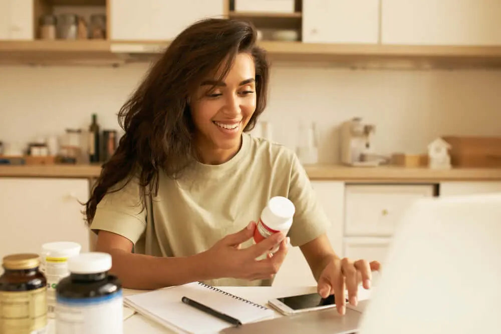 Woman smiling while holding a Zororra Plant-Based Wellness Supplements bottle.