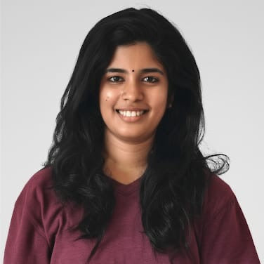 Woman wearing a maroon shirt against a plain background